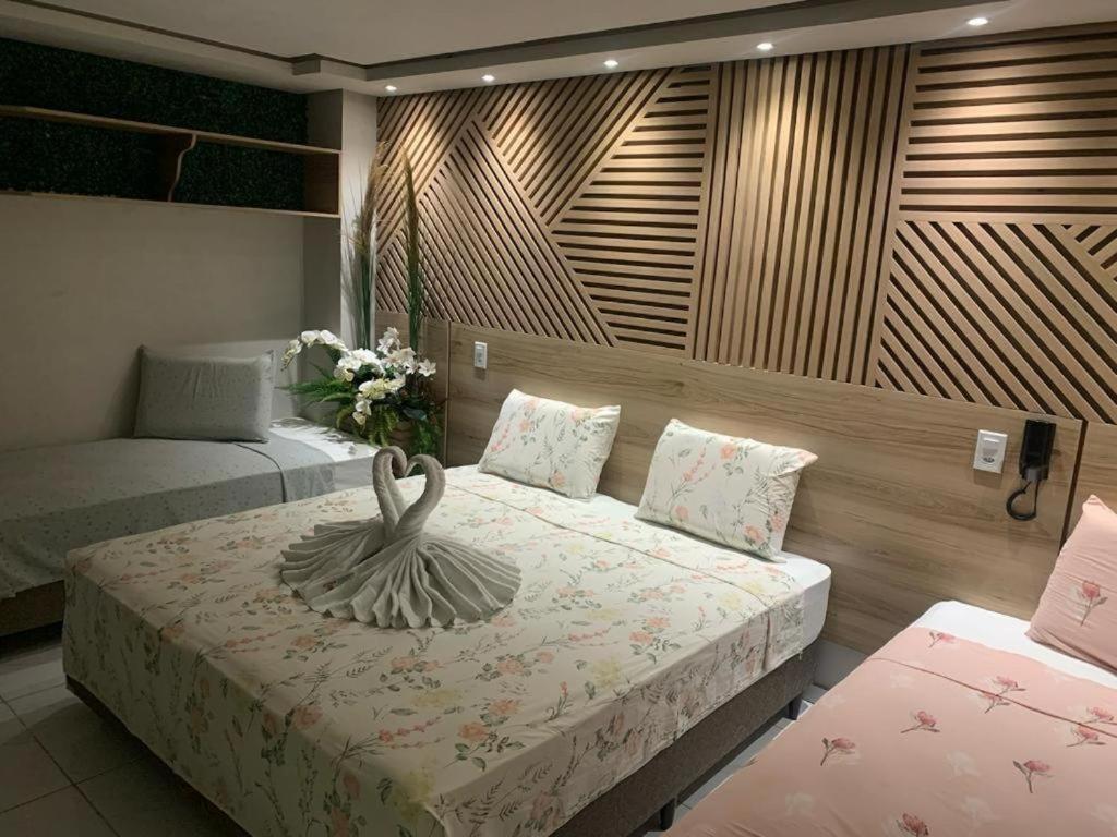 a bedroom with a bed with a swan statue on it at Pousada Beija Flor in Maceió