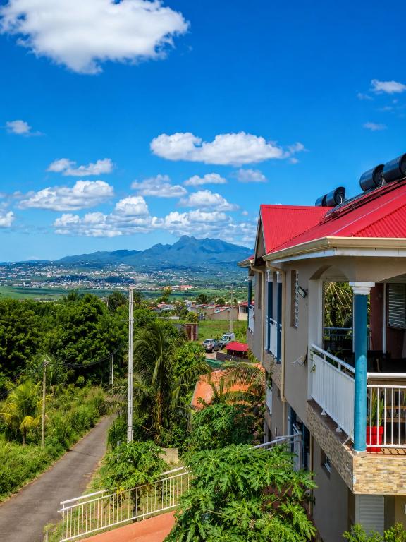 a house with a red roof and a road at Résidence Terre et Passion in Ducos