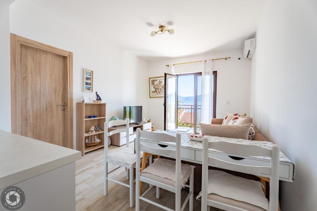 a kitchen and dining room with a table and chairs at Bonaca Apartments in Kotor