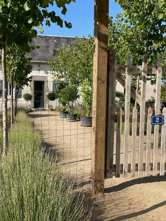 a fence with a gate in front of a house at A la terre ferme in Arnac-la-Poste