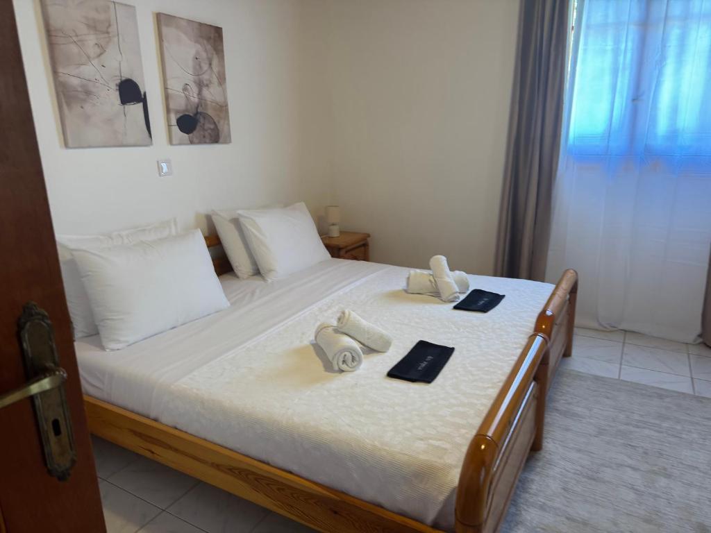 a bedroom with a large bed with white sheets at Gradakia Cottages 1 in Argostoli