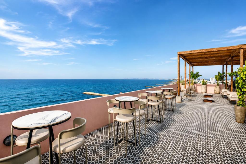 a row of tables and chairs on a balcony overlooking the ocean at Bondo Hometel in Cartagena de Indias