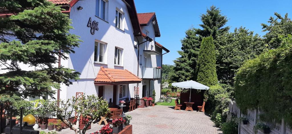 ein Gebäude mit einem Tisch und Stühlen davor in der Unterkunft Aga Mielenko Pokoje i Apartamenty in Mielenko