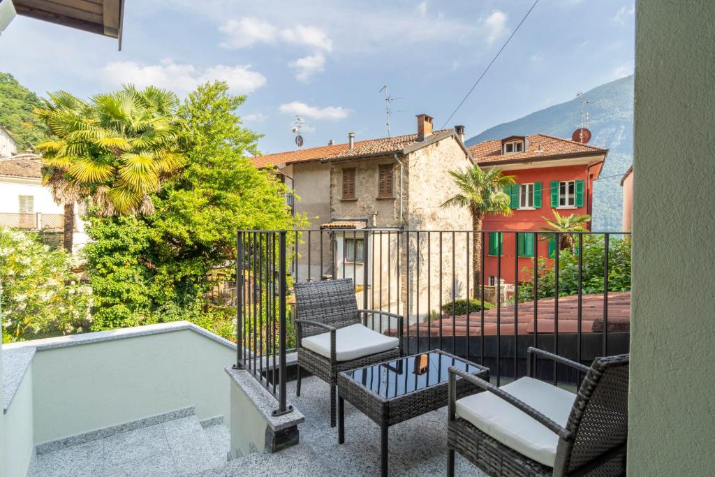 a balcony with chairs and a view of a house at Mirafiume - Lugano Lake in Valsolda