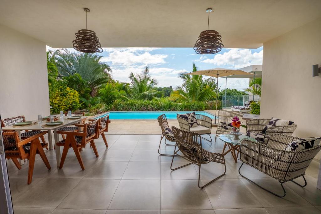 a dining room with a table and chairs and a pool at ELOMY VILLA in Albion