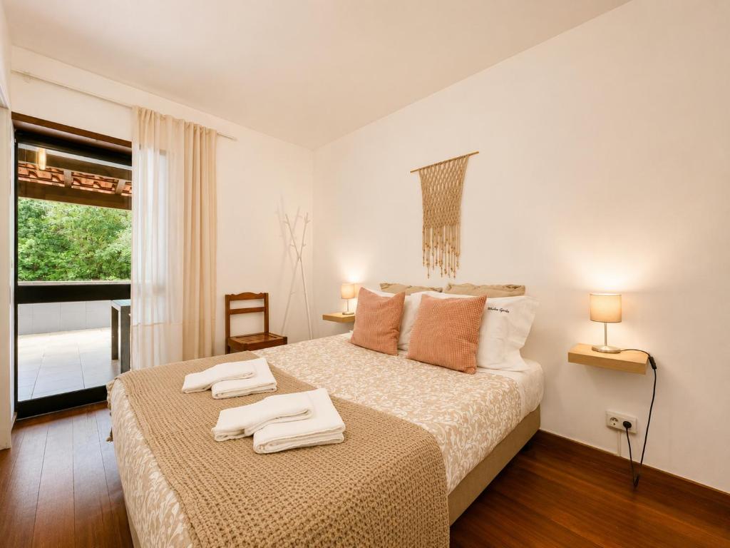 a bedroom with a bed with two towels on it at Studio Gerês in Geres