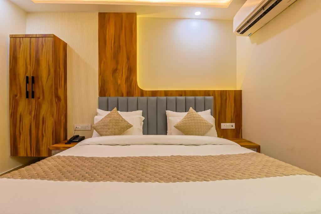 a bedroom with a large bed with white sheets and pillows at Hotel Shivmurti Temple Palace By G K Group in Varanasi