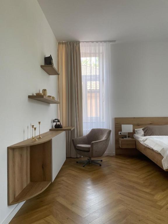 a bedroom with a bed and a desk and a chair at Hotel Zámeček na Čeladné in Čeladná