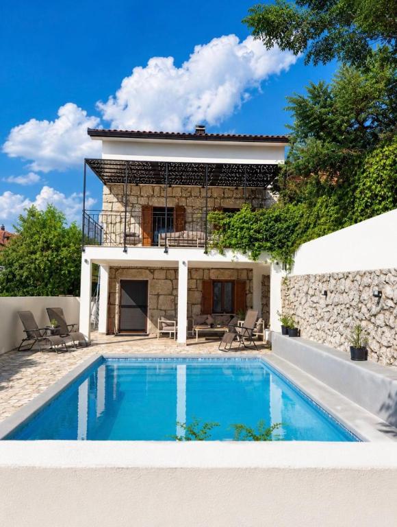 a villa with a swimming pool in front of a house at Villa "Lala" in Ljubuški