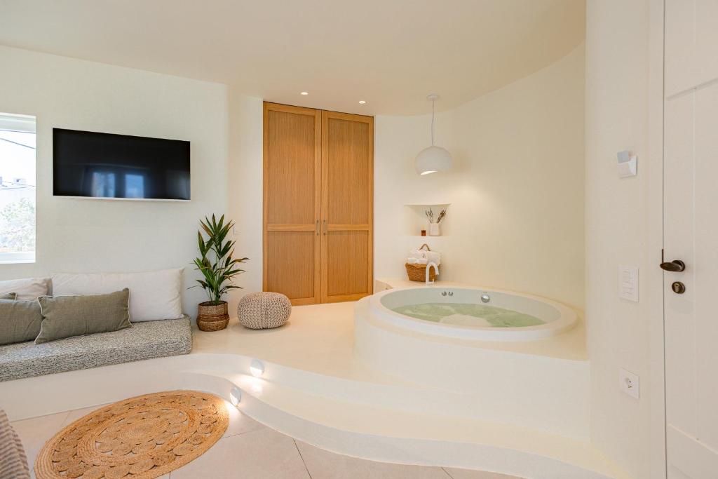a bathroom with a large tub in a room at Naxia Gaia Suites in Agia Anna Naxos