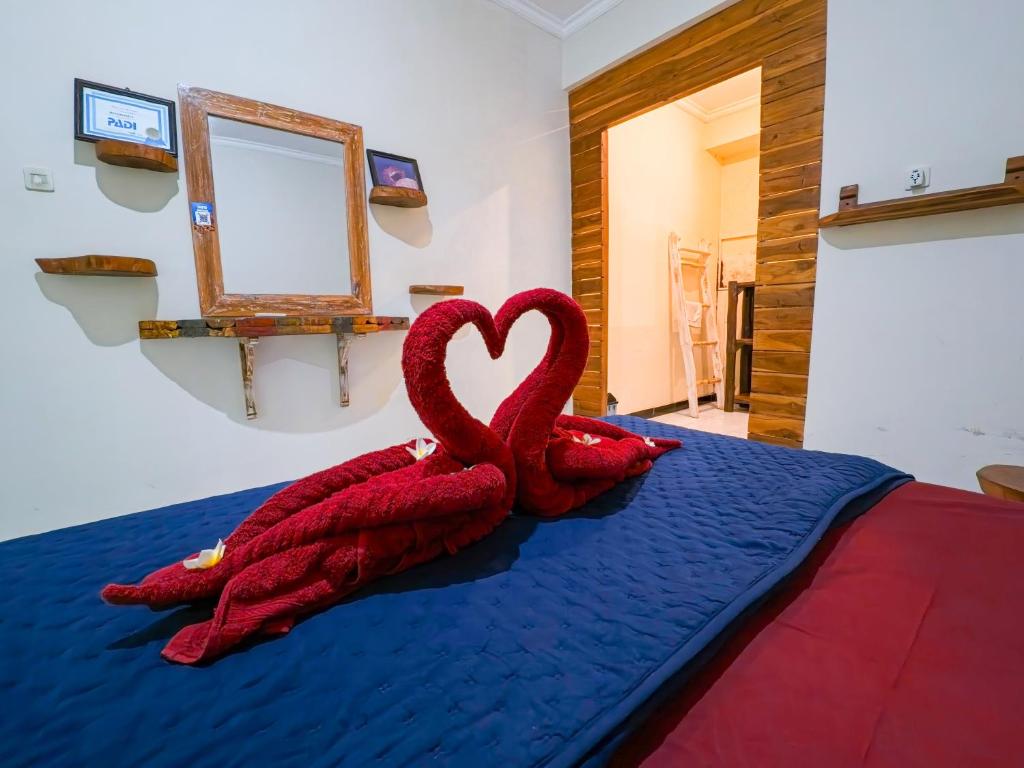 two red swans sitting on top of a bed at Sunrise Lodge & Lounge in Singaraja