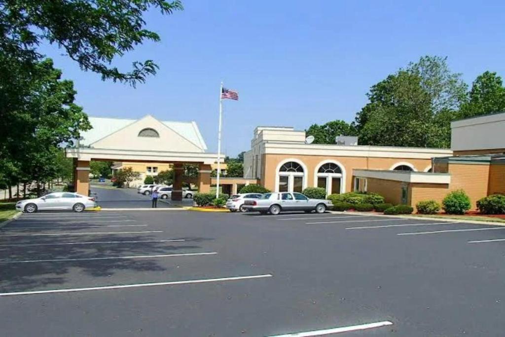 a parking lot with cars parked in front of a building at GreenRidge Hotel in Wickliffe