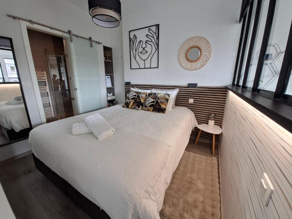 a bedroom with a large bed with white sheets and pillows at Studio Belle-Vue in Spa