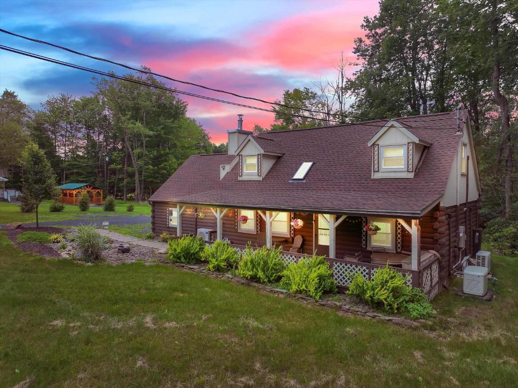 a small house with lights on in the yard at Cabin in Long Pond Gameroom Pool Table in Long Pond