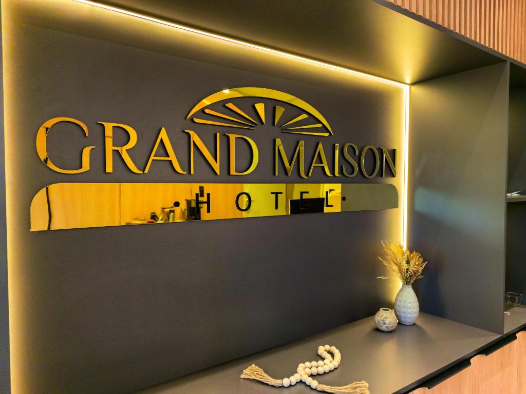 a sign for a grand malcolm hotel with a snake on a counter at Grand Maison Hotel in Porto Velho
