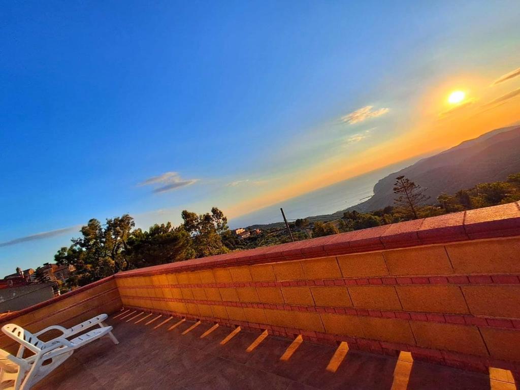 a bench sitting on top of a brick wall with a sunset at Il Ligustro Terrace in Casal Sottano