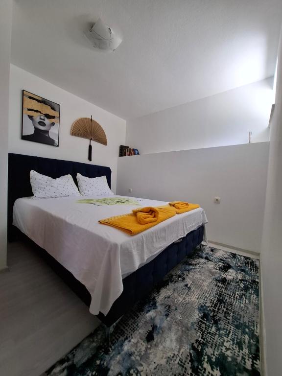 a bedroom with a bed with a yellow blanket on it at Apartman Mostar in Mostar