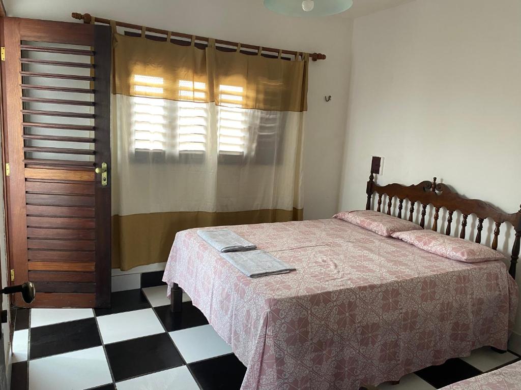 a bedroom with a bed and a checkered floor at Apartamento in Natal