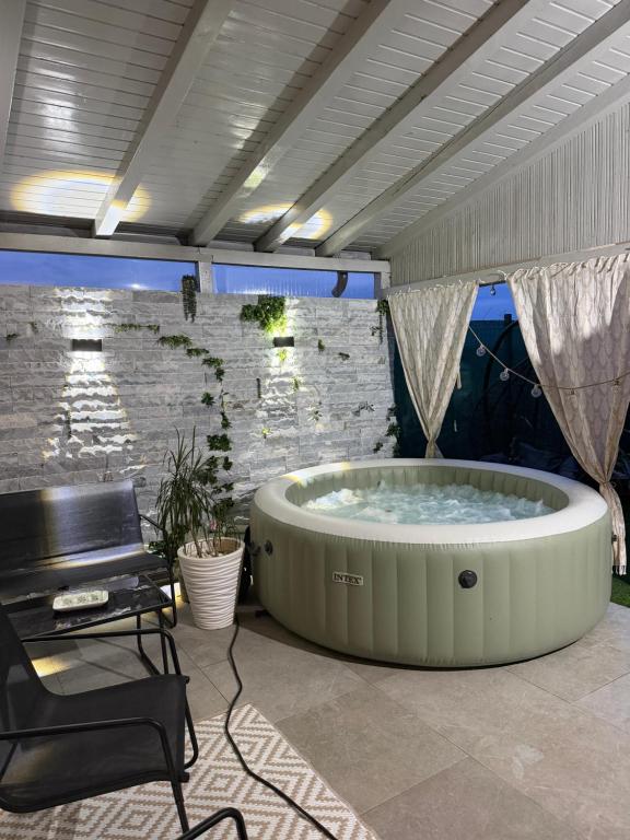 a hot tub in a room with a stone wall at The cozy escape in Satu Bucovei
