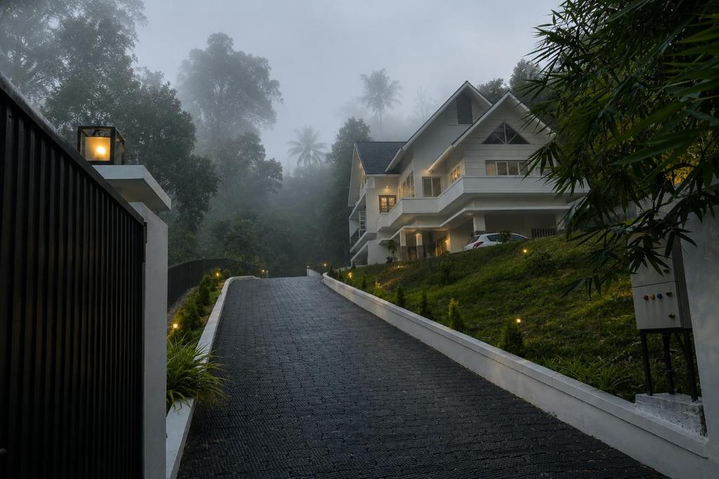 a foggy street with a house on a hill at Trinity Villa Home Stay in Idukki