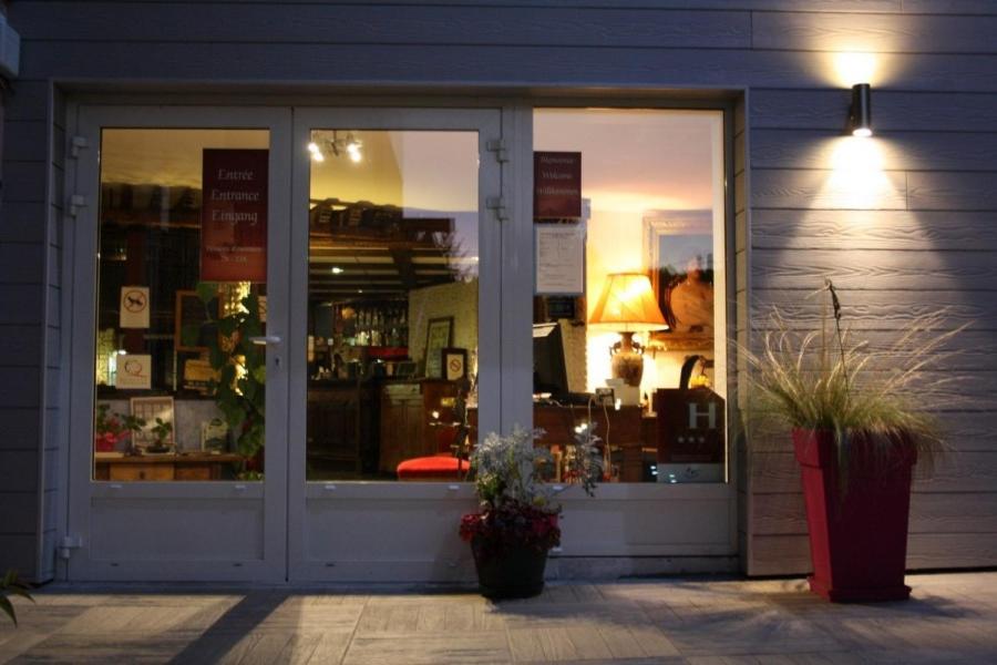 a store window with plants in front of it at Bomotel in Montluçon