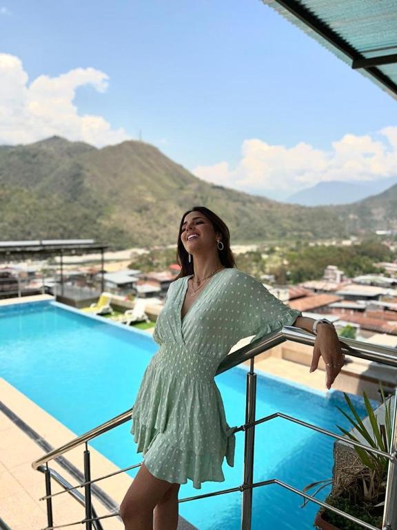 a woman in a green dress standing next to a pool at Hotel Luxor Selva in La Merced