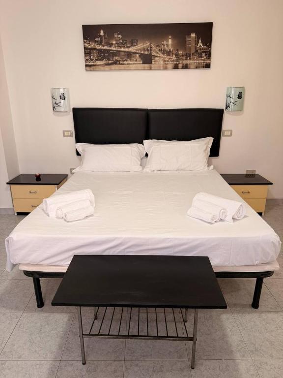 a large bed with two white towels on it at Ro's House in Assemini