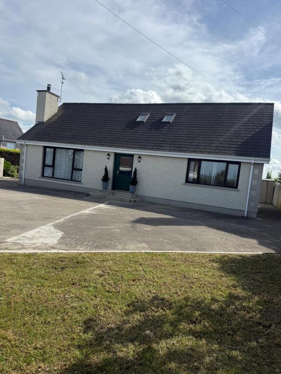 a white house with a black roof at Suzies Escape in Bovevagh