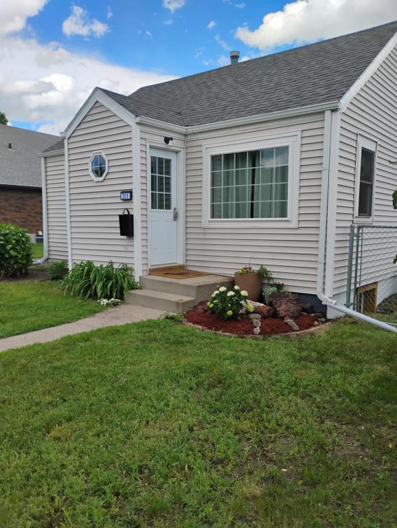 a white house with a door and a yard at 5 blocks from the hospital! in Bismarck