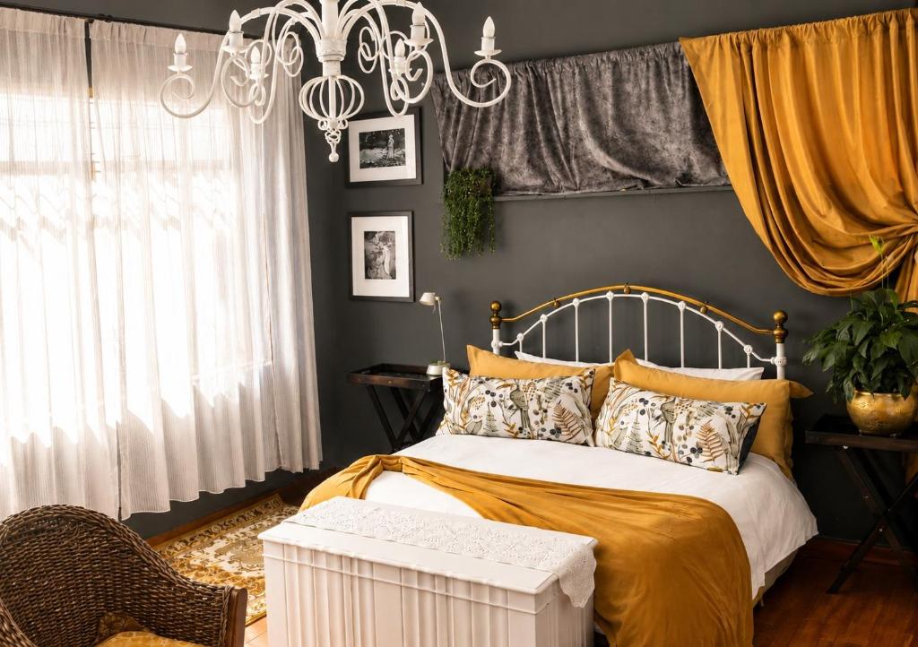a bedroom with a bed and a chandelier at Gadute Haven - Luxury Apartment in Pretoria