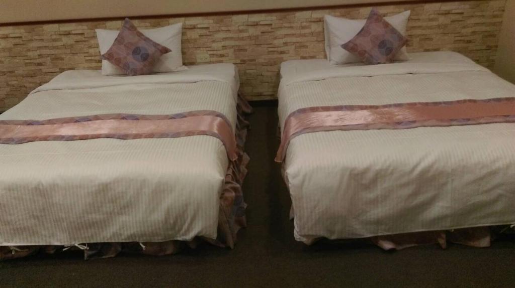 two beds sitting next to each other in a room at Gu-Ting-Ben B&amp;B in Minxiong