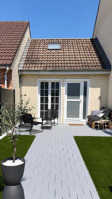 a patio with chairs and a couch in front of a house at Joli triplex proche Colmar in Sainte-Croix-en-Plaine