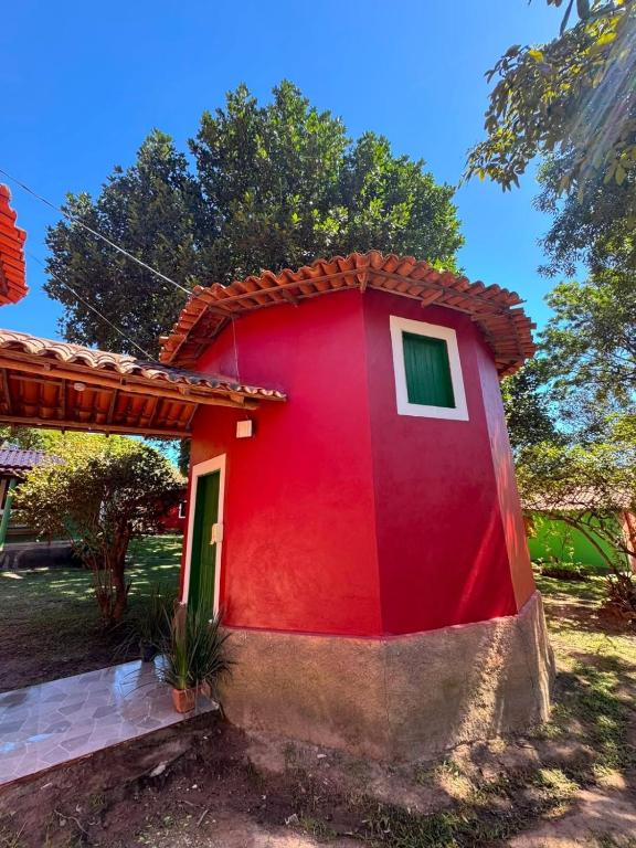 a red house with a green door at Chalé Raio De Sol in Vale do Capao