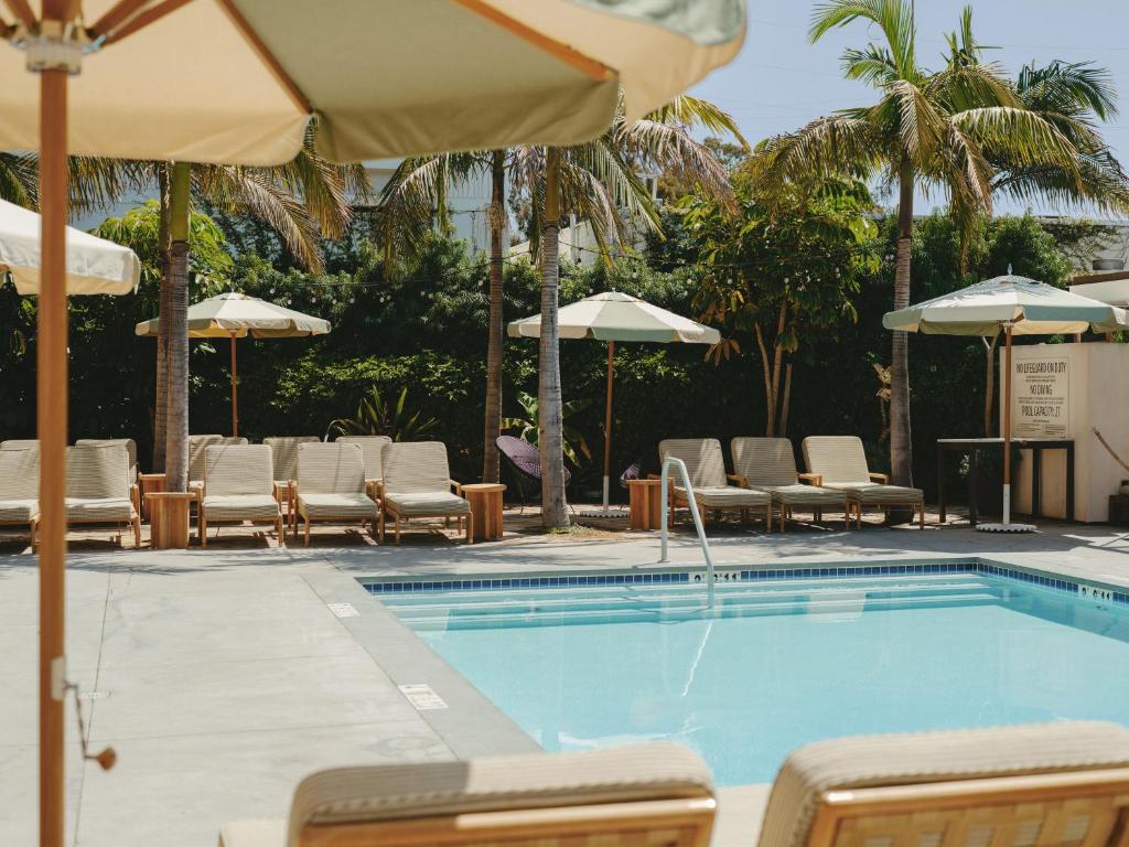 a swimming pool with chairs and umbrellas at Hotel June West LA, a Member of Design Hotels in Los Angeles