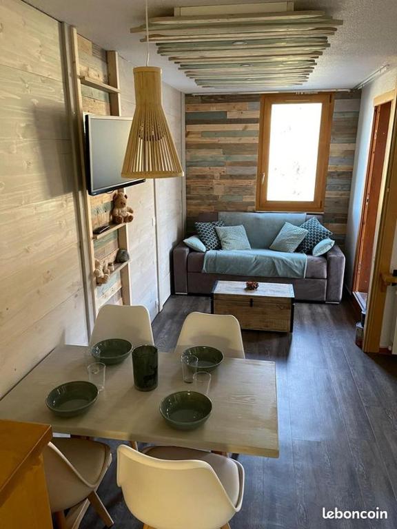 a living room with a table and chairs and a couch at Chaletttt large and magnificent view in Valmorel