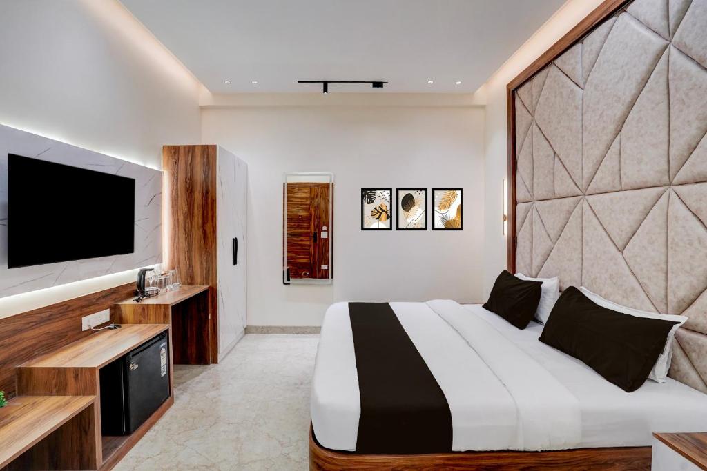 a bedroom with a large bed and a flat screen tv at Hotel O Maruti Hotel in Indirapuram