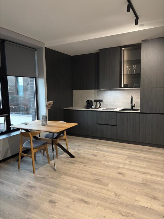 a kitchen with a wooden table and a wooden floor at Bavaro apartments 8 in Ivano-Frankivsk