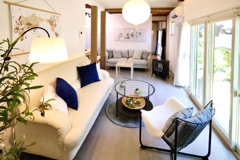 a living room with a white couch and blue pillows at Zen House - Tajimi in Tajimi