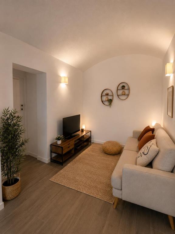 a living room with a couch and a television at Casinha do Pão Bolorento in Évora