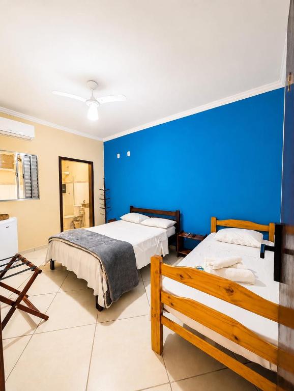 a bedroom with two beds and a blue wall at Aura de Cunha in Cunha