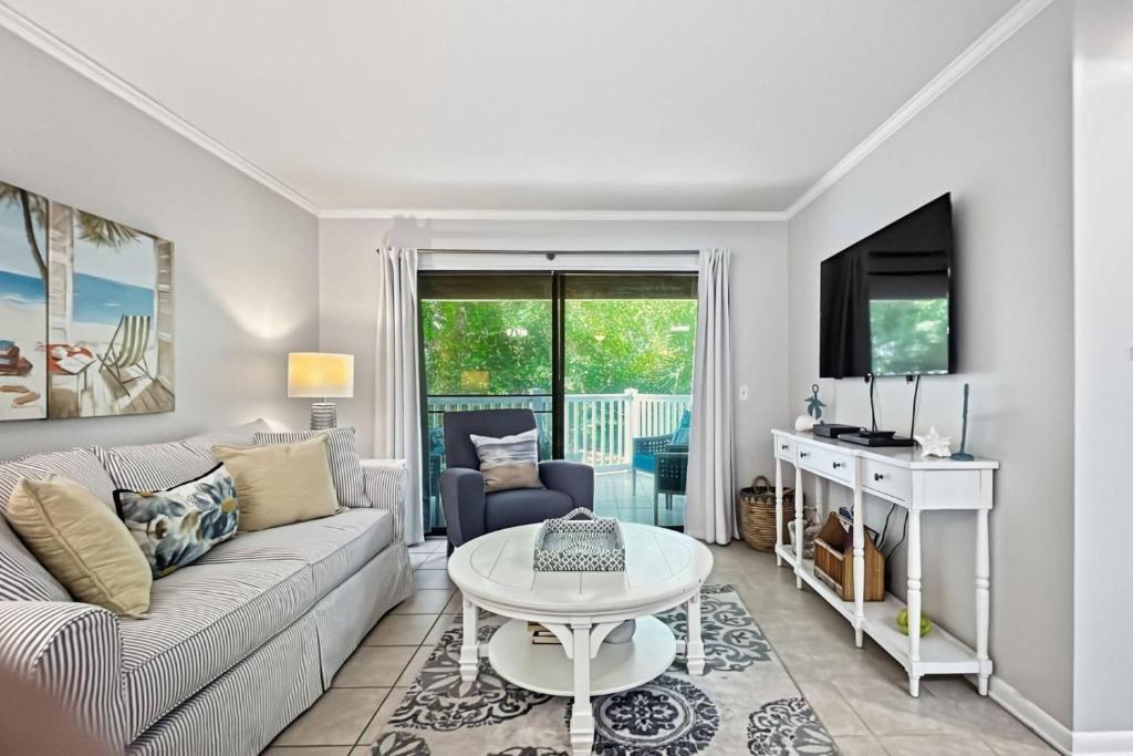 a living room with a couch and a table at Shipwatch #114 in East End