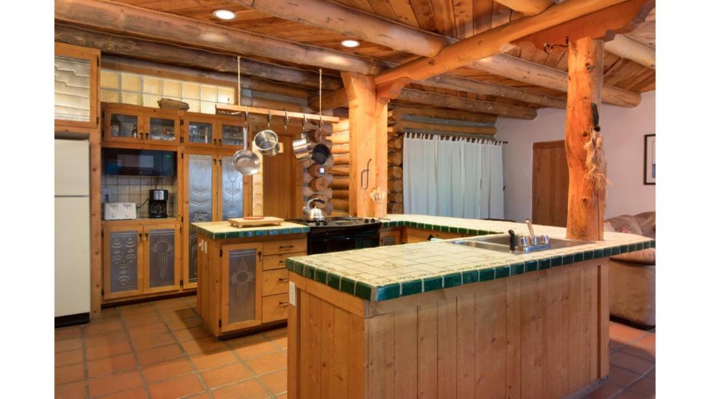 a large kitchen with wooden walls and wooden counters at Denton Cabin in Taos Ski Valley