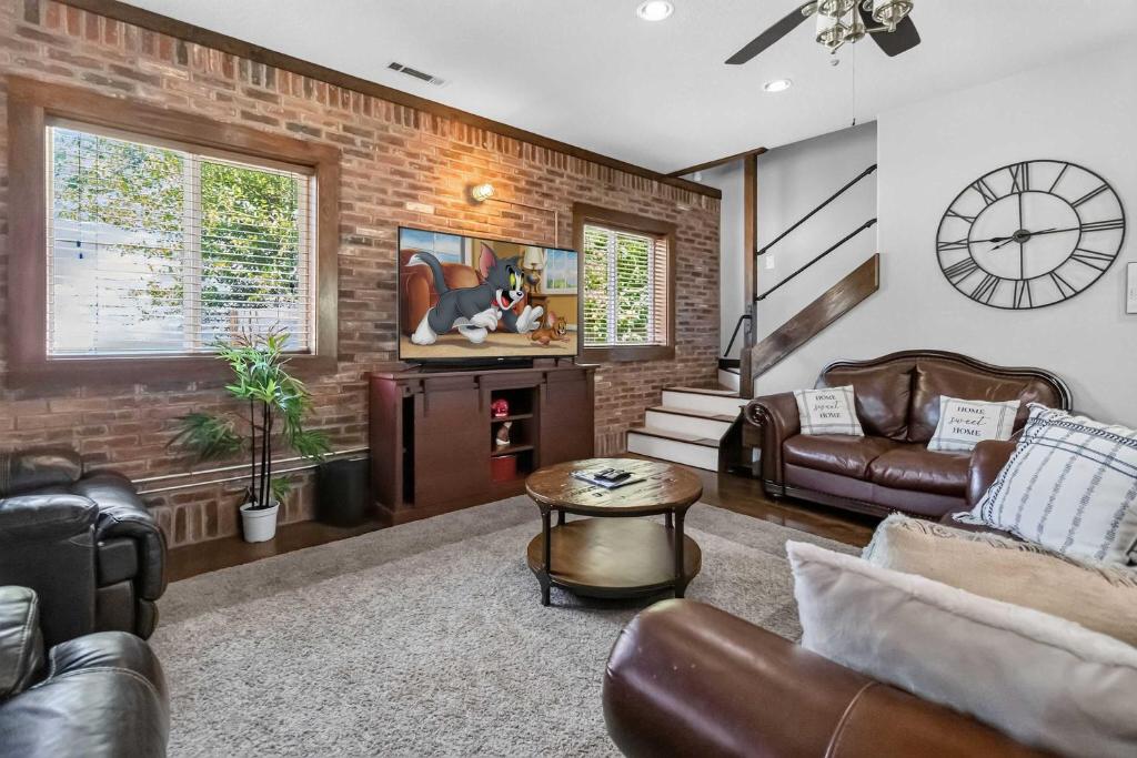 a living room with leather furniture and a clock at Beaver Lake Hideaway in Lowell