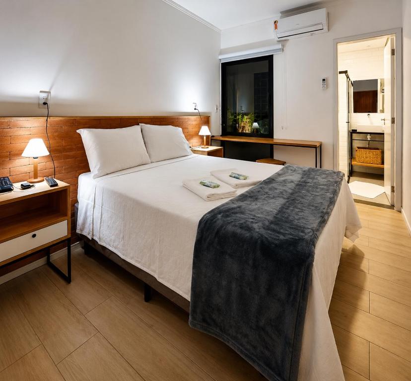 a bedroom with a large bed with a nightstand and a bed sidx sidx sidx at Requinte Hotel in São Paulo