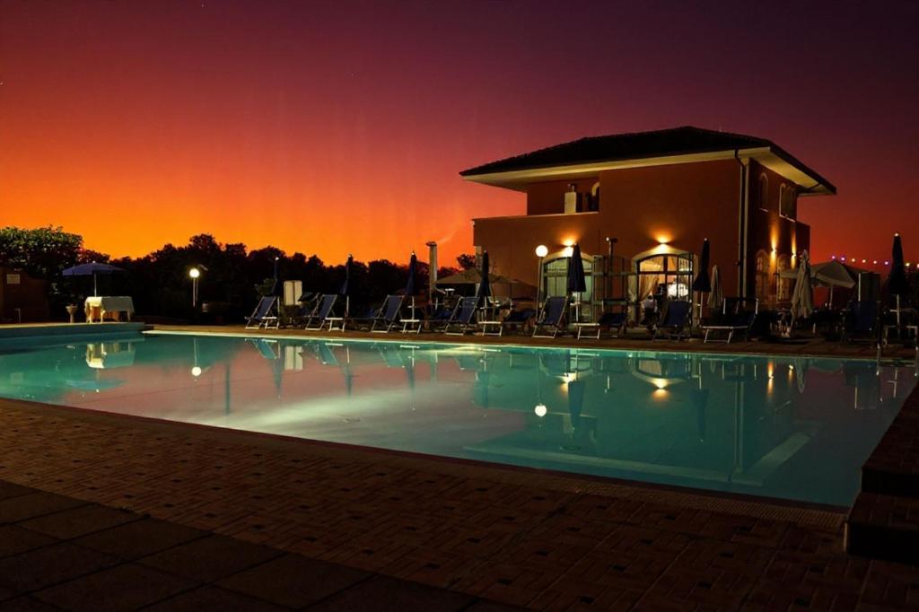 a swimming pool at night with a building in the background at Villa Cilento, PISCINA CAMERE APPARTAMENTI & RISTORANTE in Capaccio-Paestum