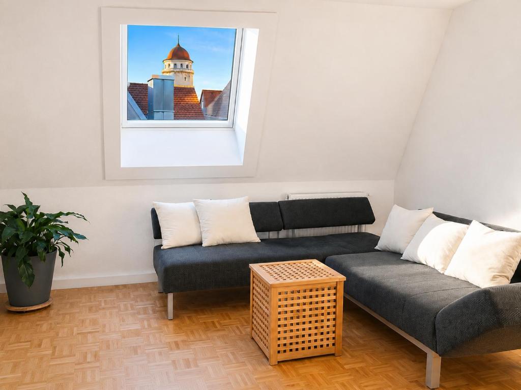 a living room with a couch and a window at SCHEE Panorama Apartment - ideal für Gruppen und Familien in Nördlingen