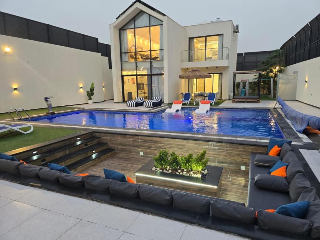 a house with a swimming pool and a house at Madrid Luxury Villa in Al Rama