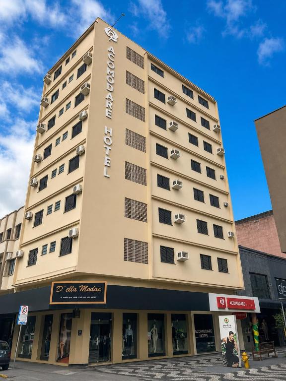 a tall building with a sign on the side of it at ACOMODARE HOTEL- SOB NOVA Direção in Tubarão
