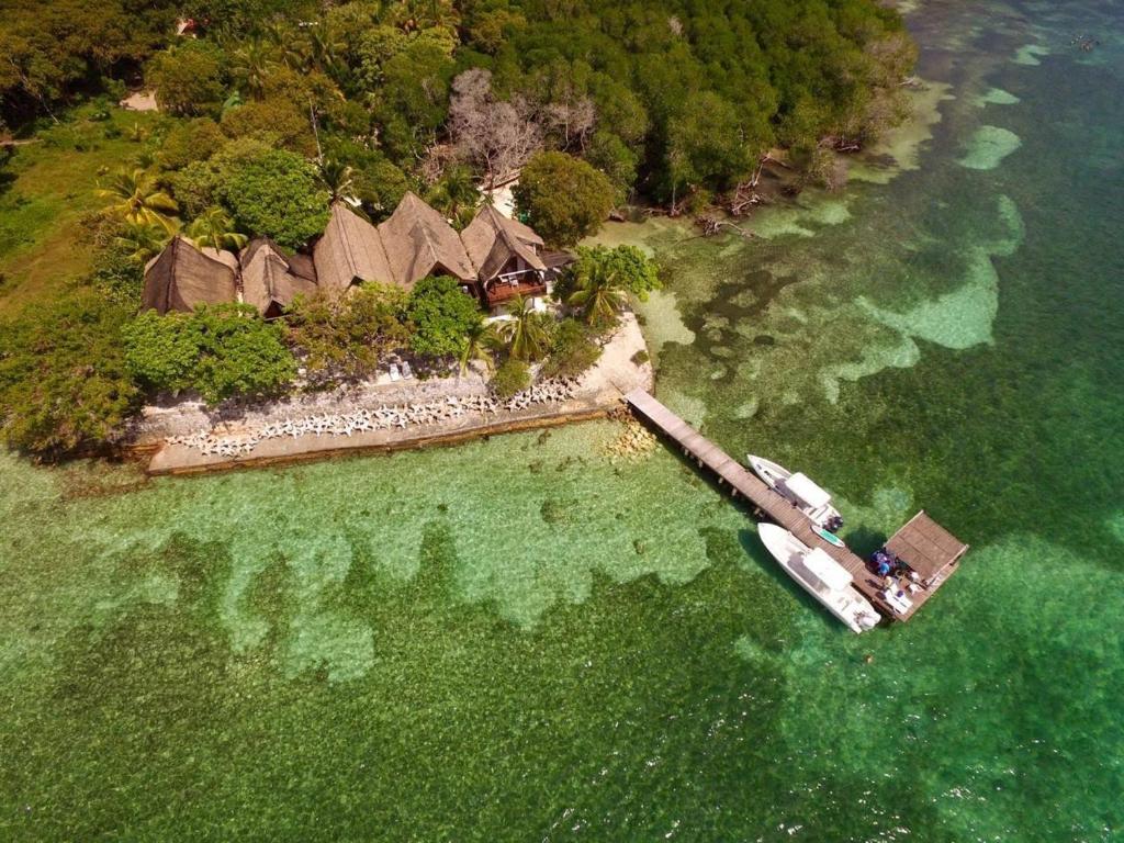 an island with a house and a boat in the water at Isla Risa in Cartagena de Indias