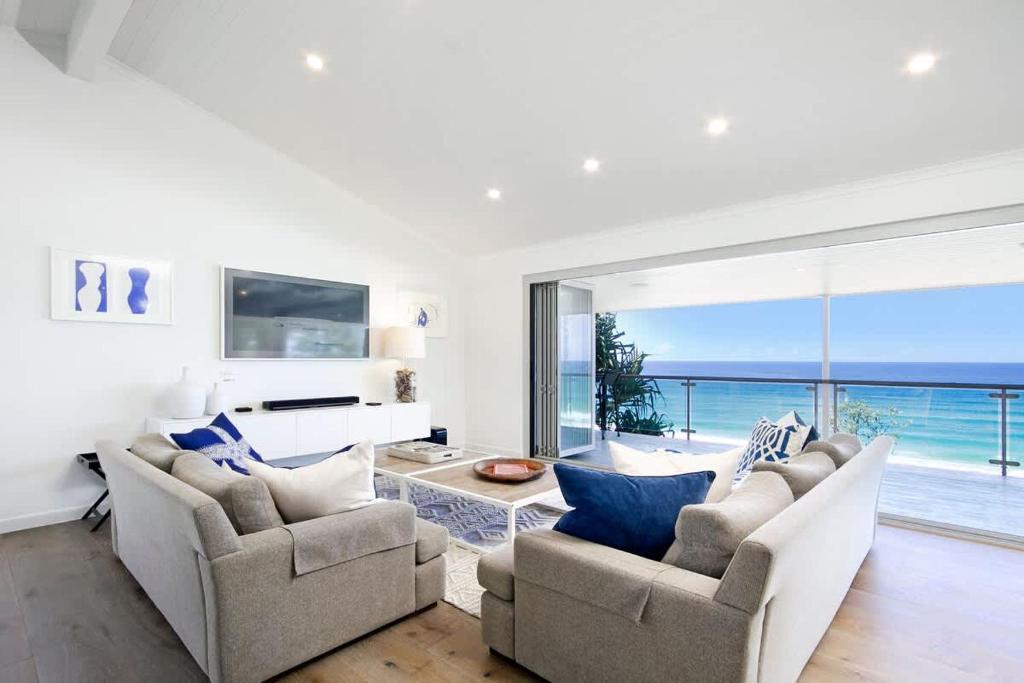 a living room with two couches and a view of the ocean at Ocean Panorama With Private Pool! in Noosa Heads